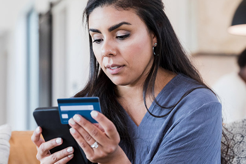 image showing woman on phone with credit card - 1 Billion Consumers