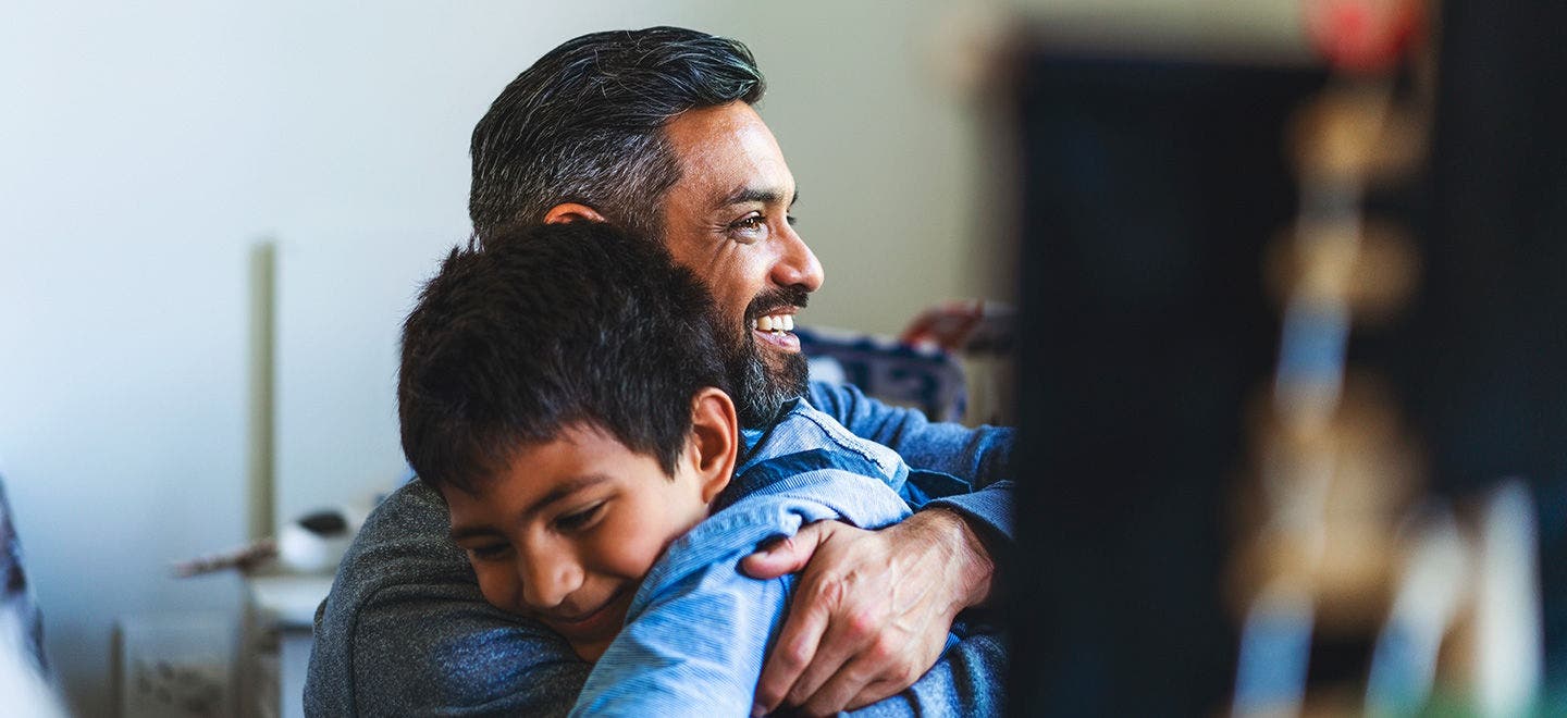 A picture of a dad and his young son hugging. Consumer vulnerability is key concern during the cost of living crisis.