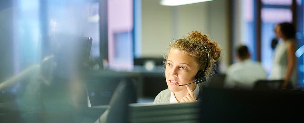 A customer care assistant speaking to a consumer on the phone.