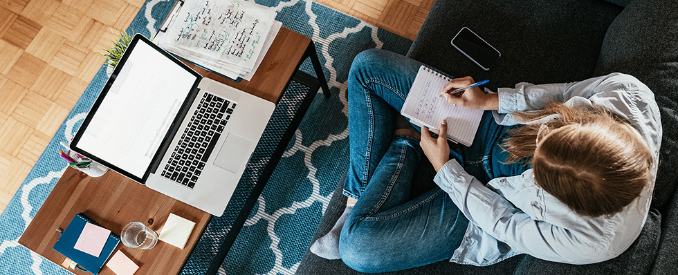 A consumer at a laptop making a list of actions